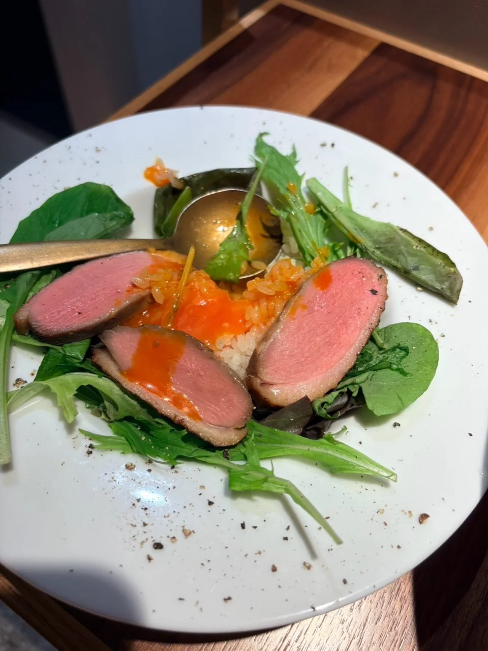 ご飯と葉野菜に肉を添えた一皿